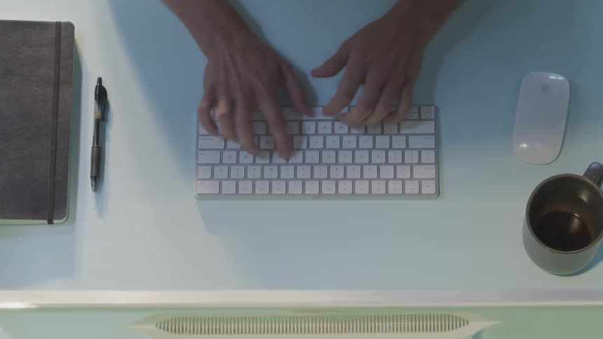 Man types on keyboard and drinks coffee throughout the day