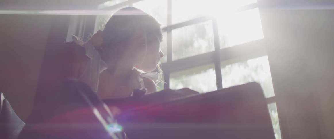 A woman tales notes at her desk as the sun streams through a georgian window