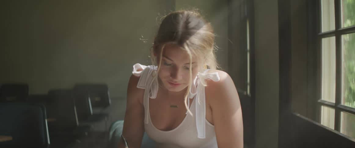 A woman sits near the window