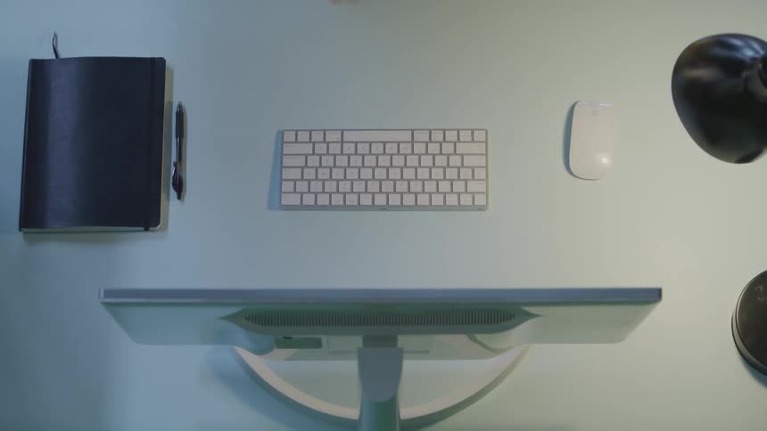 A person is typing on a keyboard and takes his cup