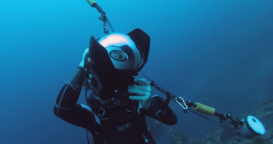 A diver swims in the ocean with a camera