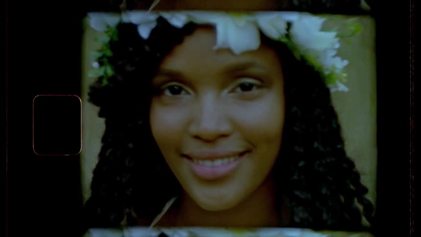 A smiling woman wearing a white flower hair garland