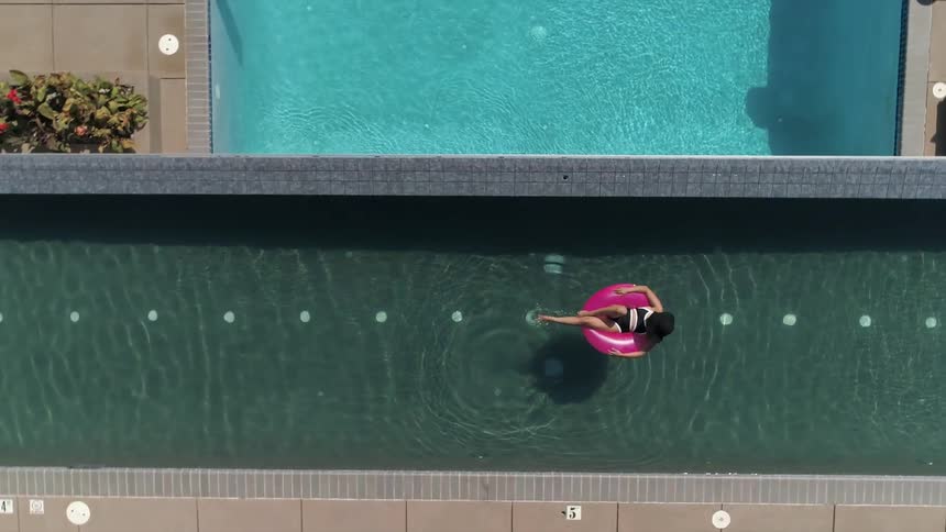 A woman relaxing in an infinity pool in an inflatable tube