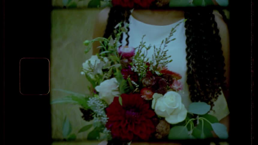 A woman is holding flowers in the field