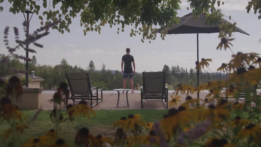 A man stands at the edge of a poll and looks out to the horizon