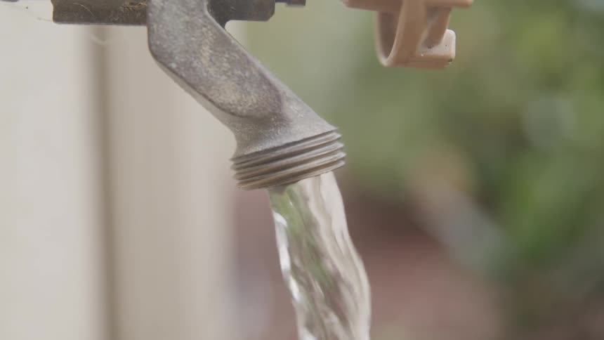 Water pours from an outdoor faucet