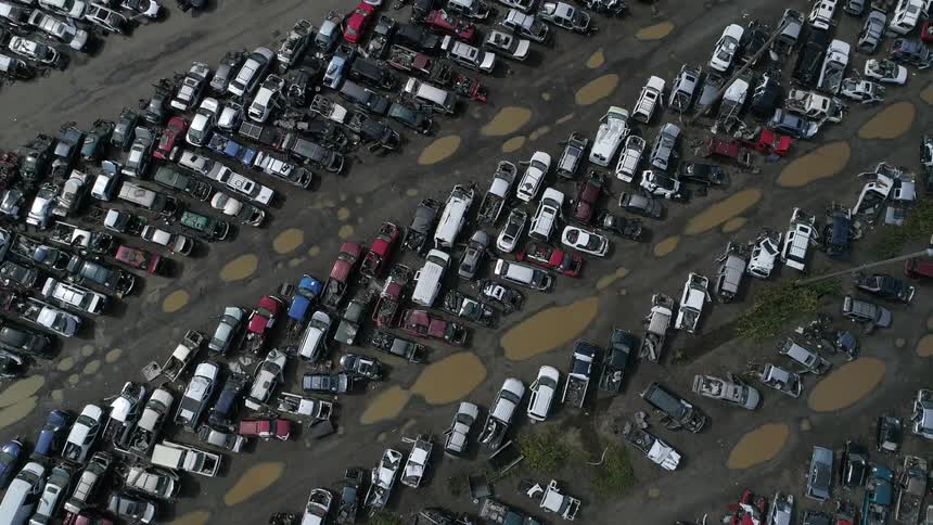 Birds eye view of vehicles parked in a dirt area with puddles of water