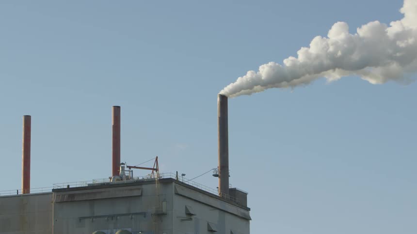 Smoke pours out of a chimney on a factory