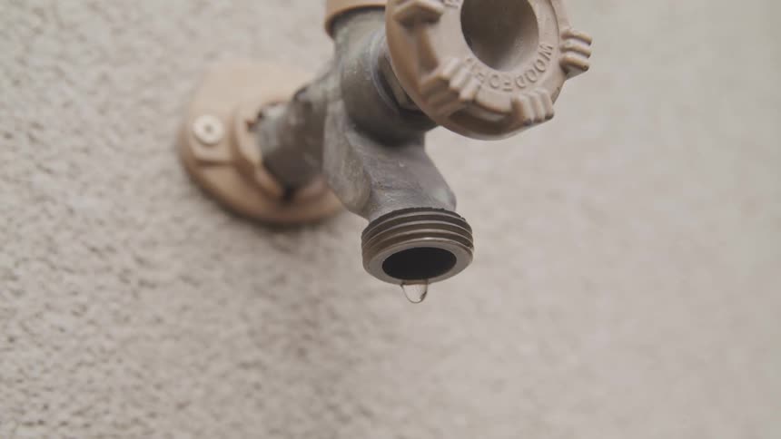 Water is dripping from a faucet outdoors
