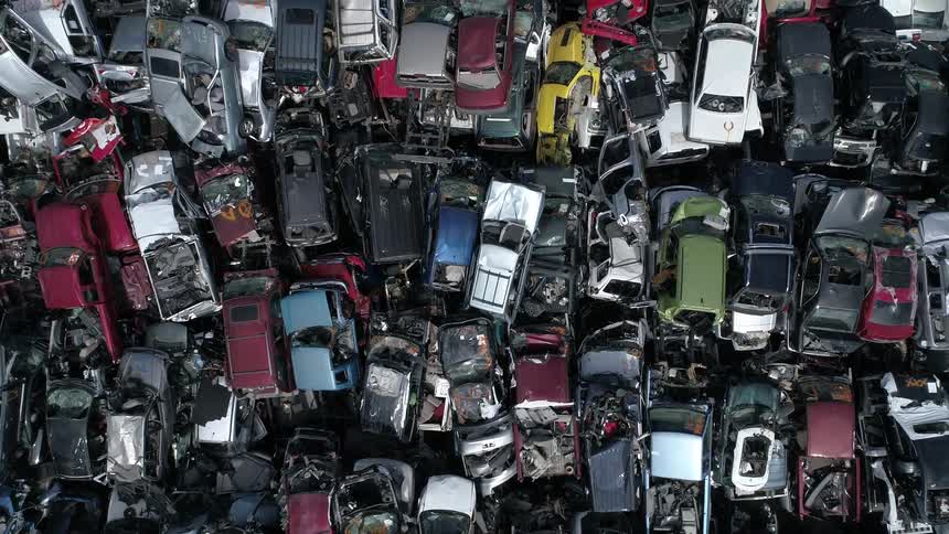A pile of broken and partially gutted cars