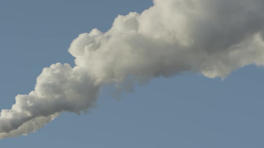 Smoke rolls across a clear blue sky