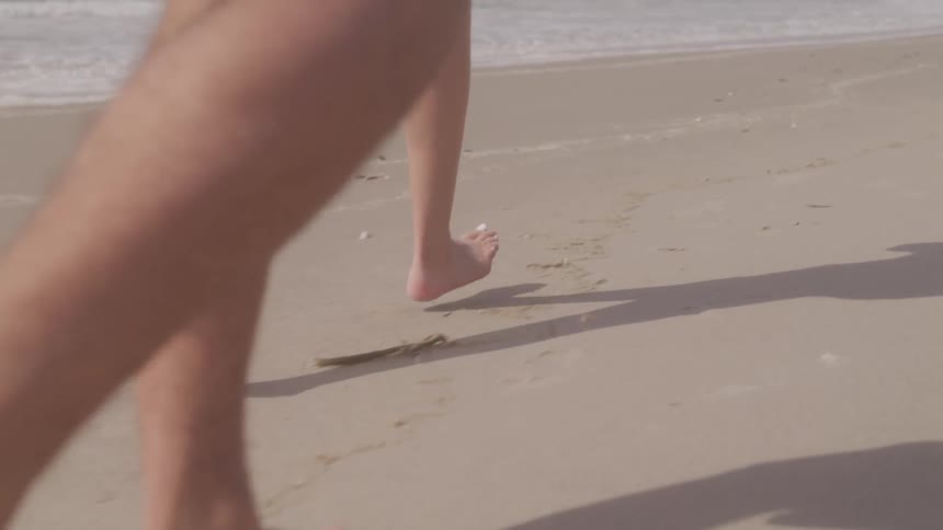 A footage of couple legs running on the beach