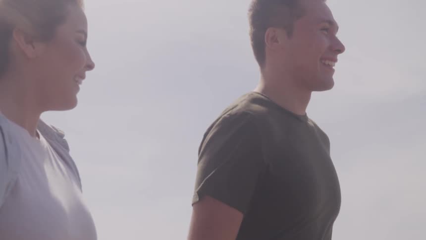 Blonde woman and man go on a walk on a windy day