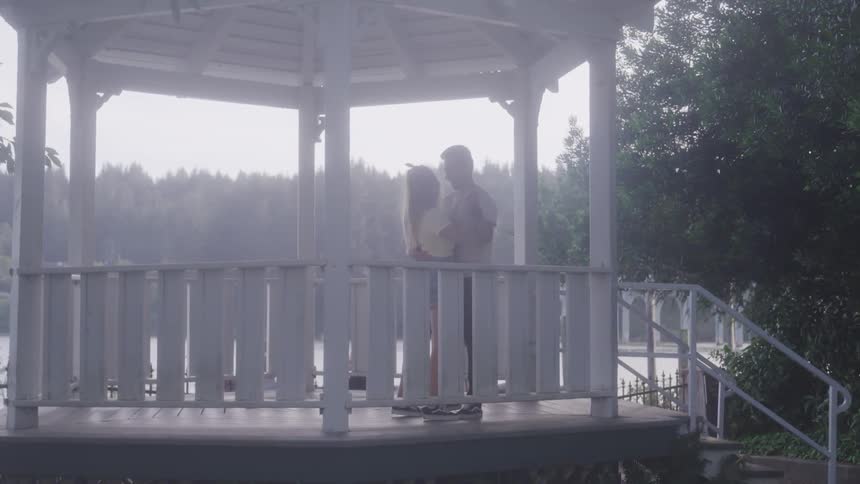 A man and woman dance in a gazebo