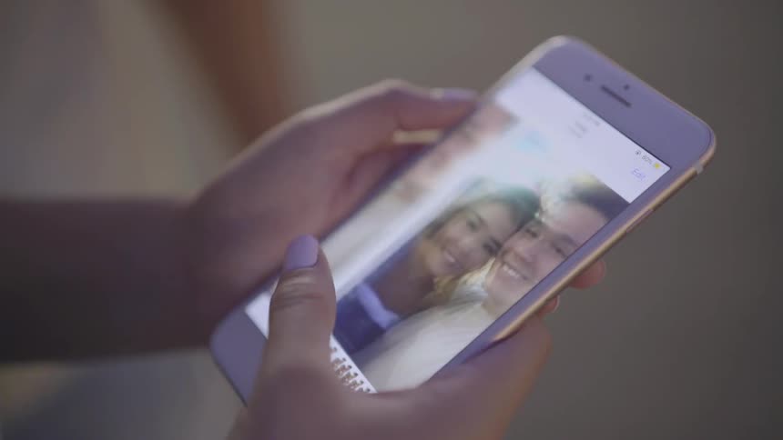 A girl scrolls through pictures on her phone