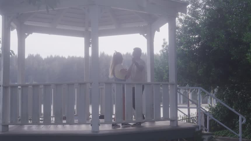 A man and woman dance in a gazebo