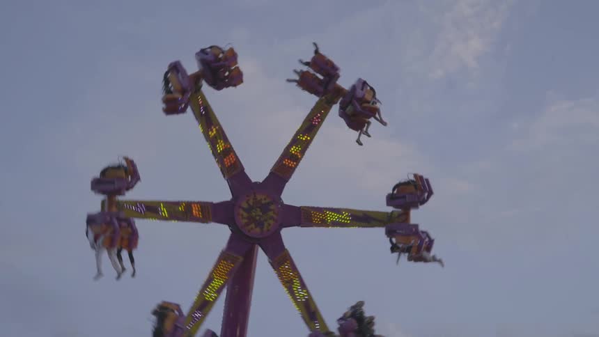 People riding a vertical spinning ride at an amusement park