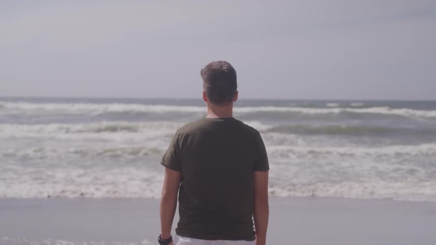 A man stand near the beach on a windy days