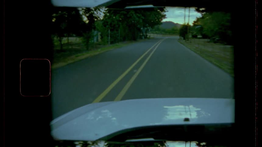 Film footage of a car driving down a street