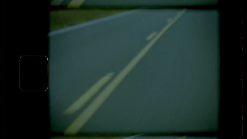 A vehicle drives down a two lane road