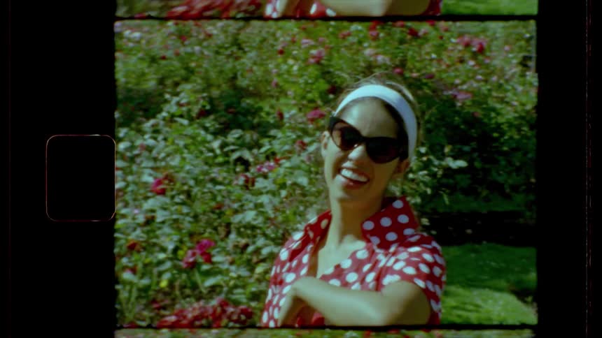 A woman is being video taped and waving at the camera