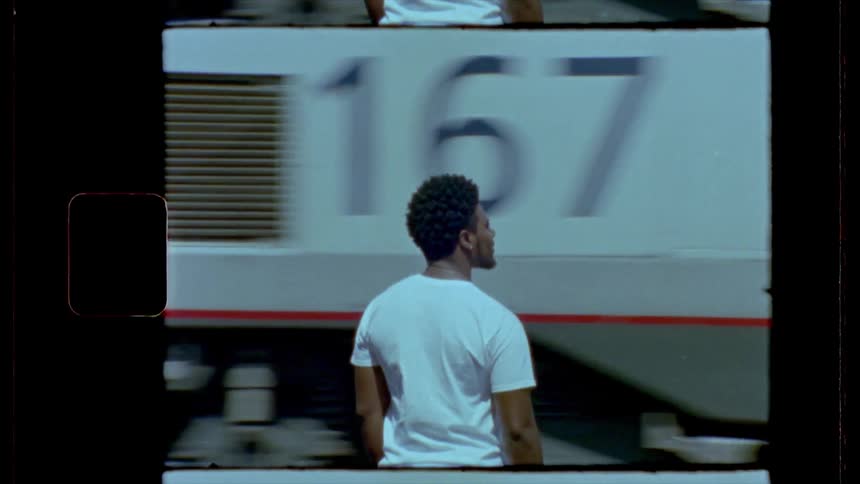 Film footage of a black man watching a train go by