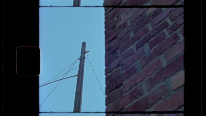 A footage of a brick wall and an electric pole