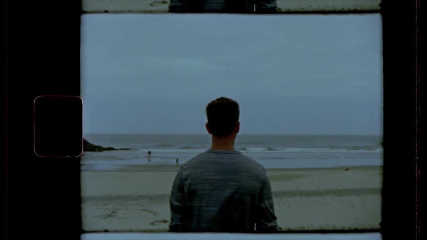 A vintage footage of man standing in beach