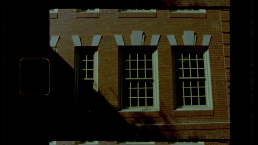 A multi story brick building has several windows of various sizes
