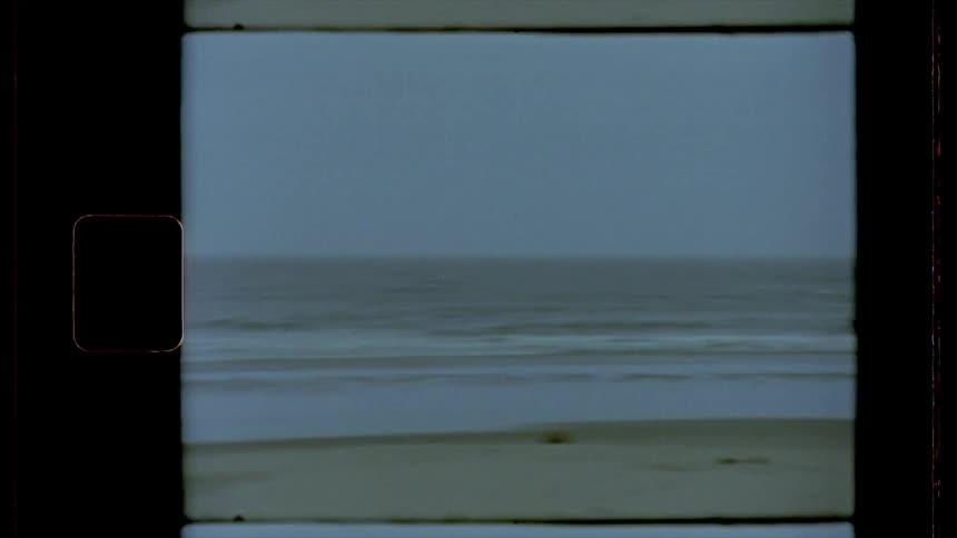 A house sits on a hill right next to a beach