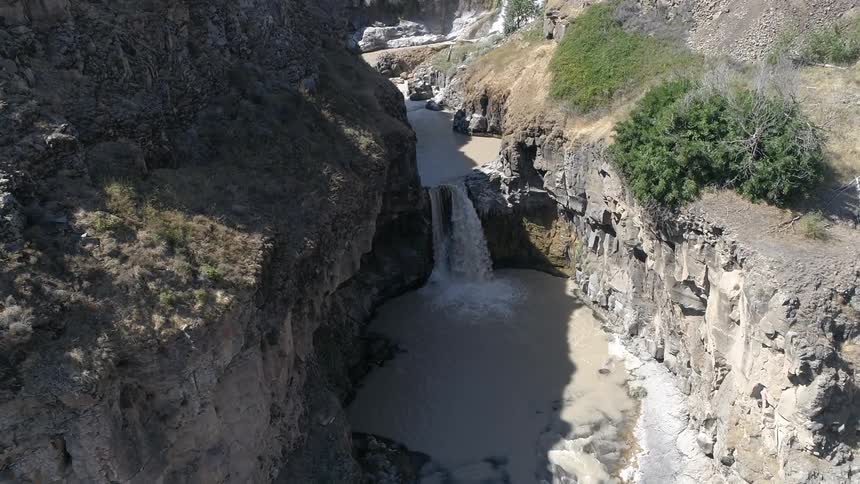 An aerial scenery of a rocky cliff and waterfall