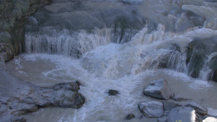 A stream of murky water running rocks
