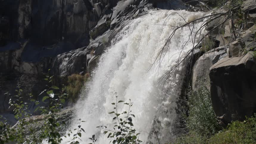 A waterfall crashes in to the river below