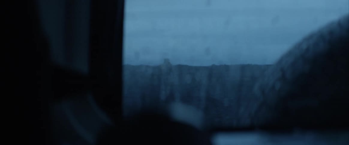 A person carrying a backpack walking away as a vehicle drives away from them