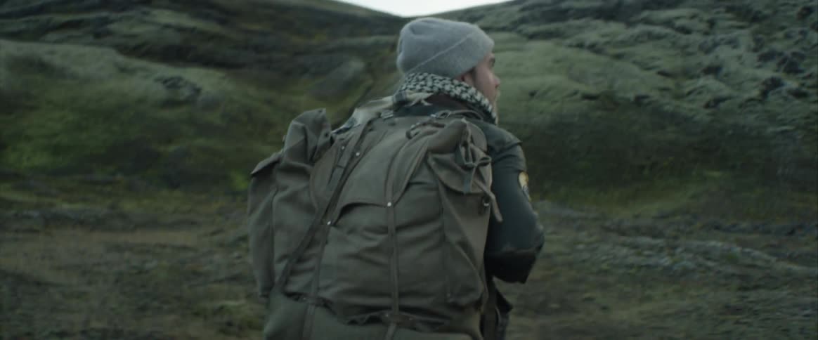 A person is hiking outdoors while carrying a backpack