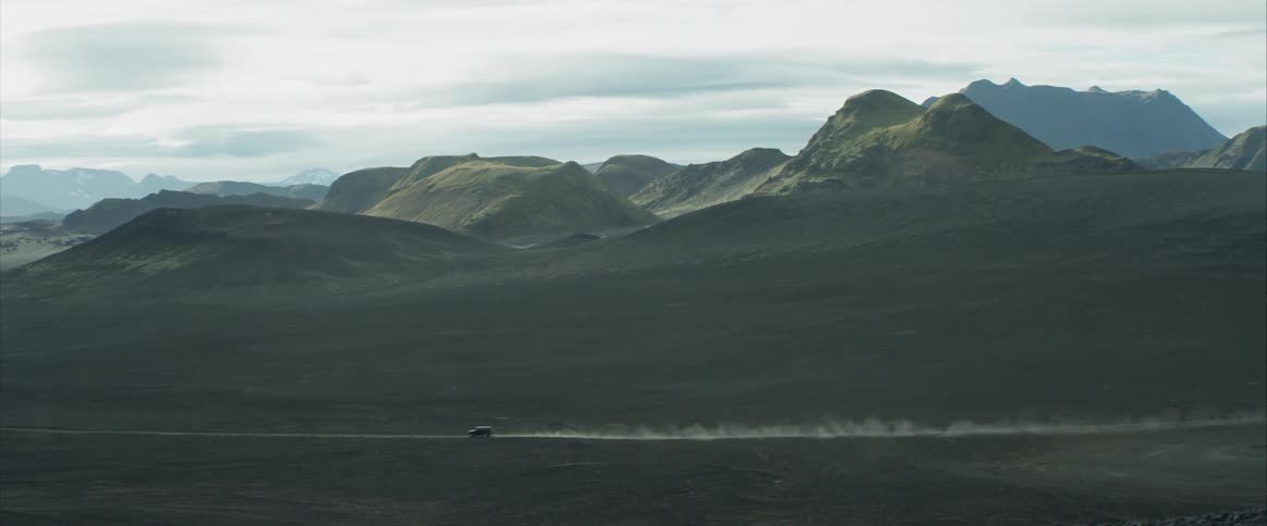 A car driving in front of mountains
