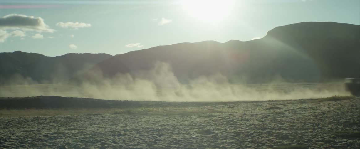 A car is driving through a rural area
