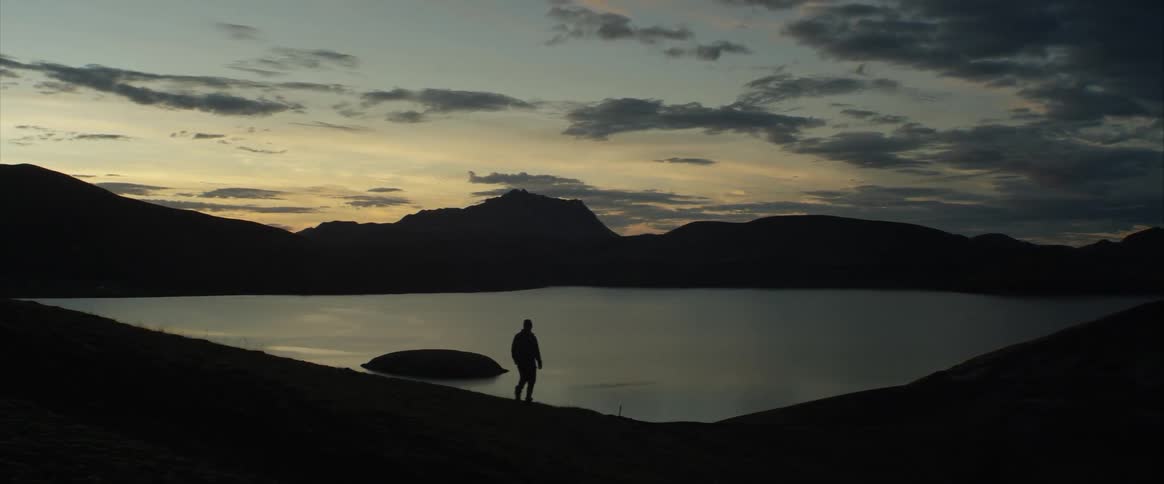 A man walk alone near the lake
