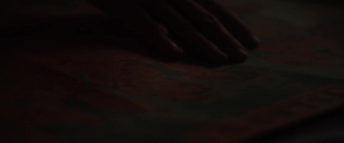 A person running their hand across a map in a dark room