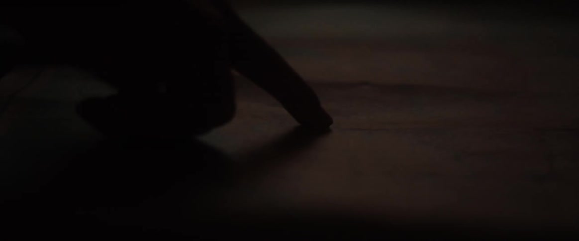 A person wipes the wood with their finger