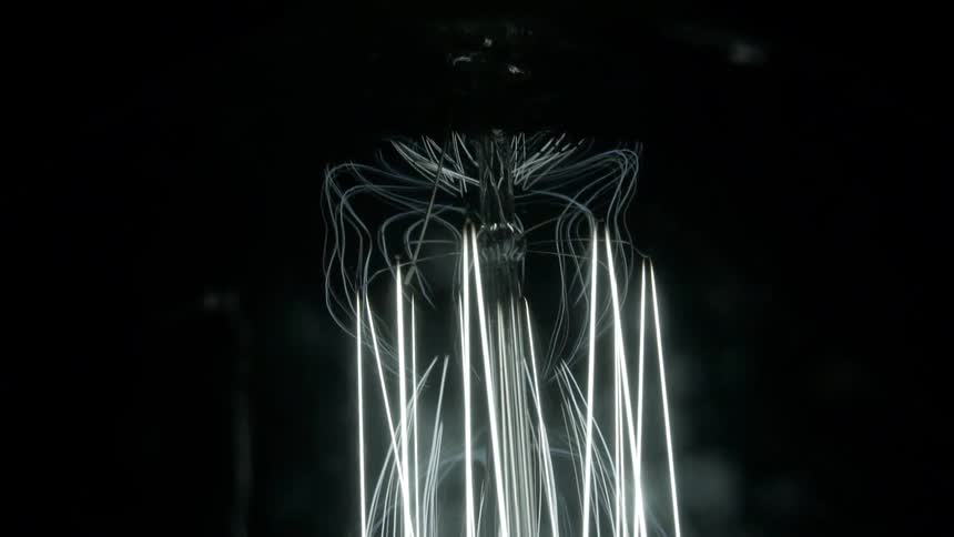 Glowing lights form an octopus like image in front of smoke