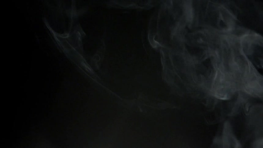 Smoke rises and swirls against a black background