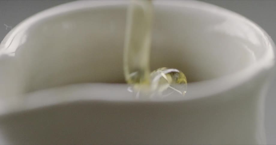 Honey is poured into a ceramic jug