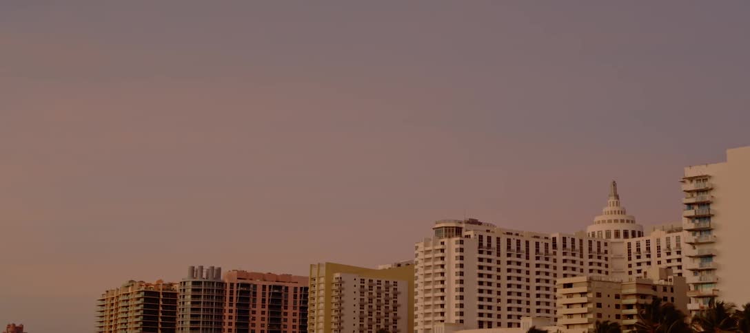 The sun sets in front of several high rise apartment buildings