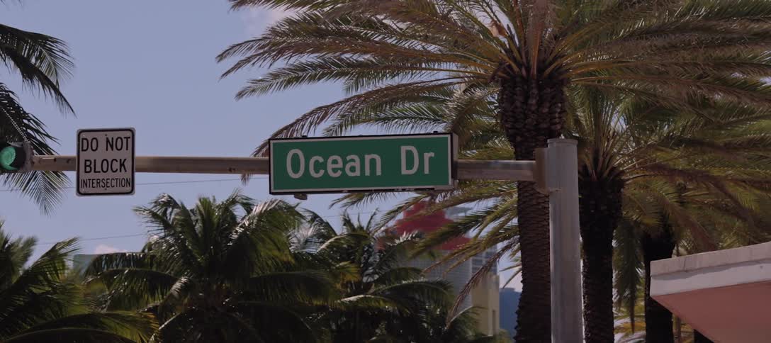 A street sign hangs on a traffic light pole