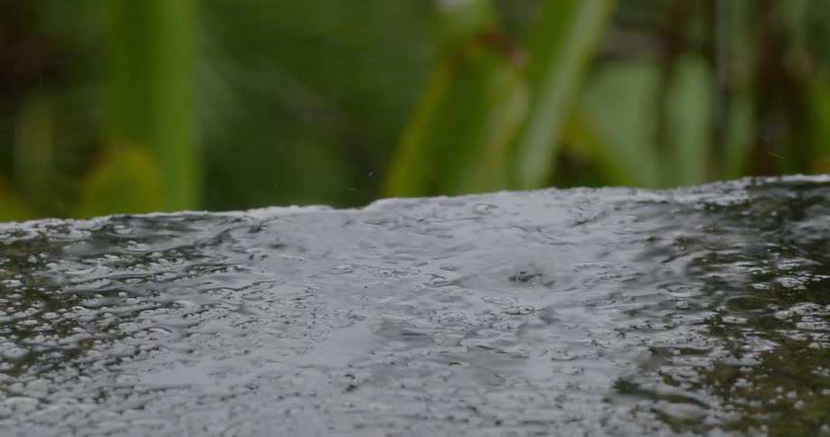 Rain falling and splashing on concrete