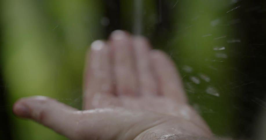 A persons hand catching rainwater