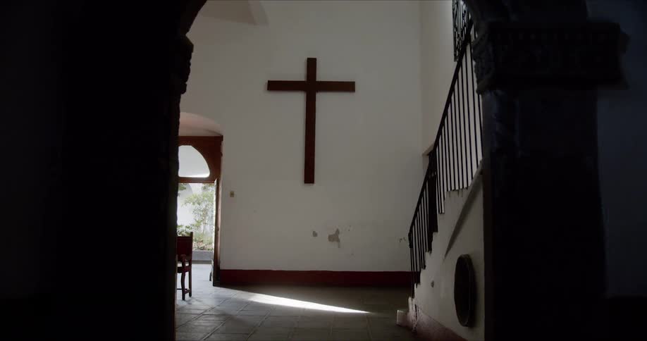 A large cross hangs on a wall near the entry way
