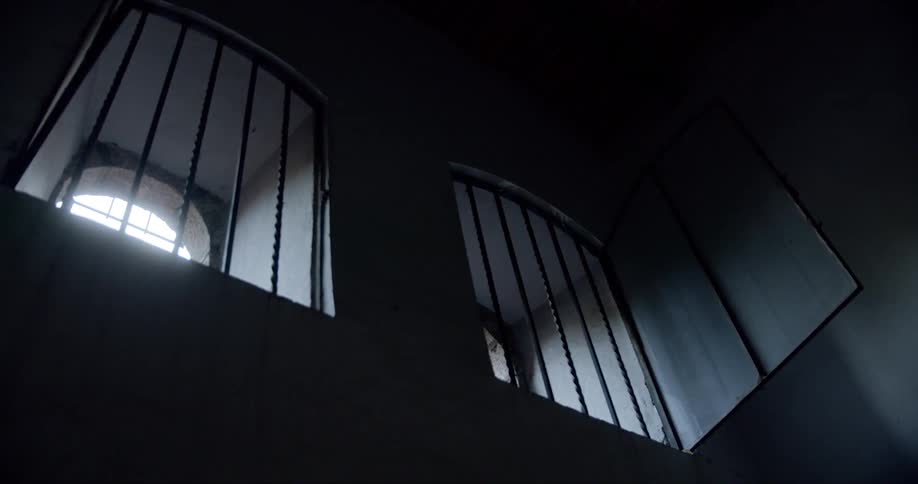 Sunlight shines into room through high barred windows