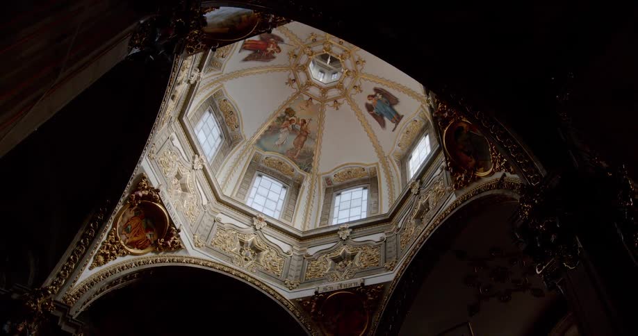 A intricately painted dome inside of an old beautiful church